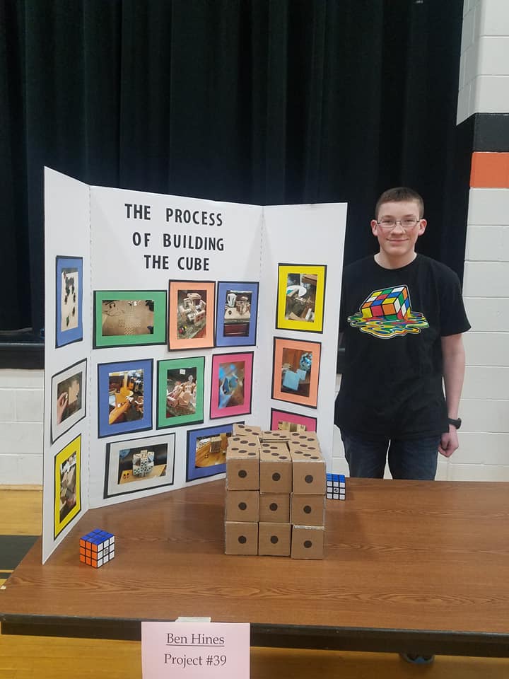 boy standing in front of a cardboard display